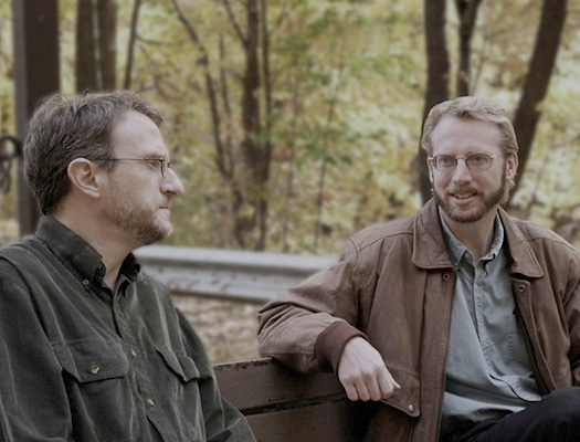 Men talking on bench at park