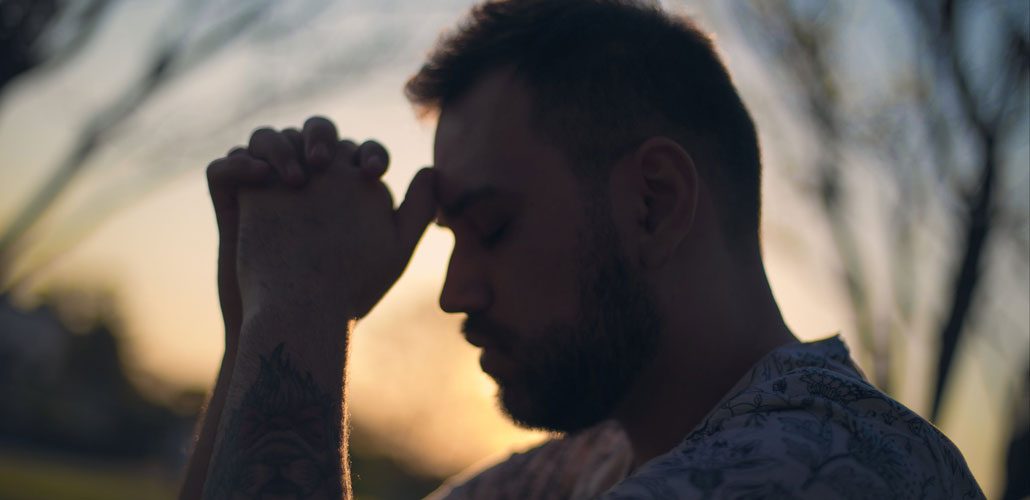 Man resting head on clasped hands