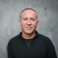 Photo of Dr. Jesse Zlotnik in front of a grey wall