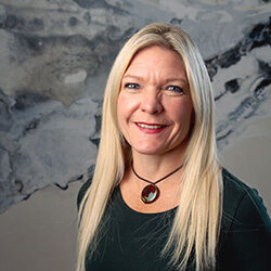 A professional headshot of Chantelle Beach in front of a marbled wall