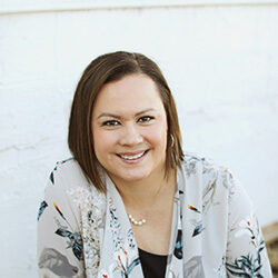 A photo of Dr. Laurie Ali in front of a plain white wall