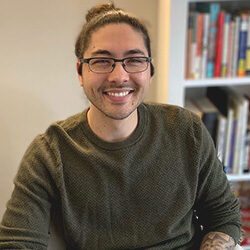 A photo of Joseph Harrington sitting in front of a bookcase