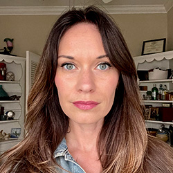 A photo of Dr. Mackenzie Lambine in front of some shelves
