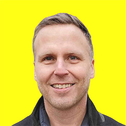 A photo of Alan Bordeville in front of a solid yellow background