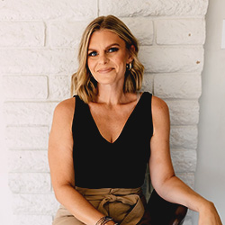 A photo of Dr. Audra Horney sitting in front of a white brick wall